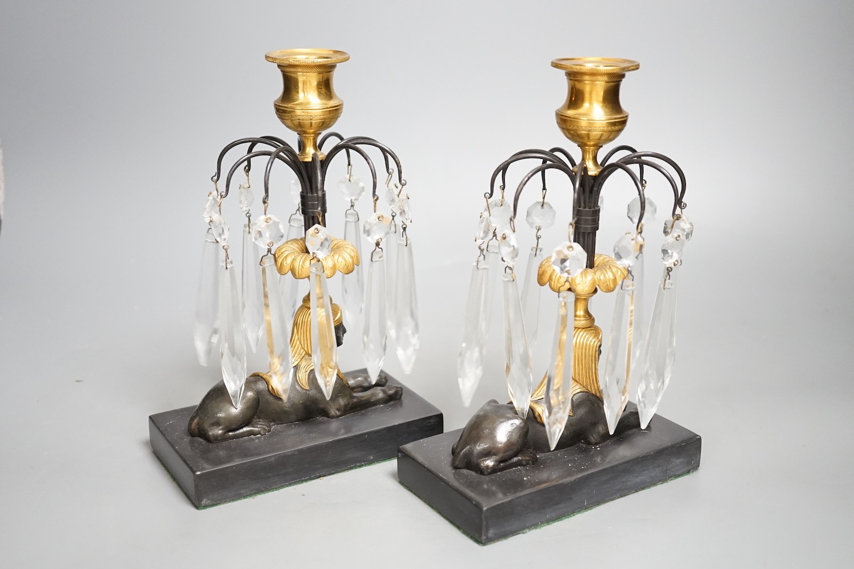 A pair of gilt bronze and glass lustre drop 'sphinx' candlesticks, 21cm